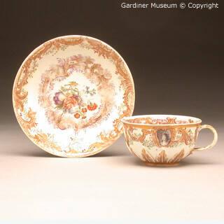 Teacup and saucer painted with cameos and flowers