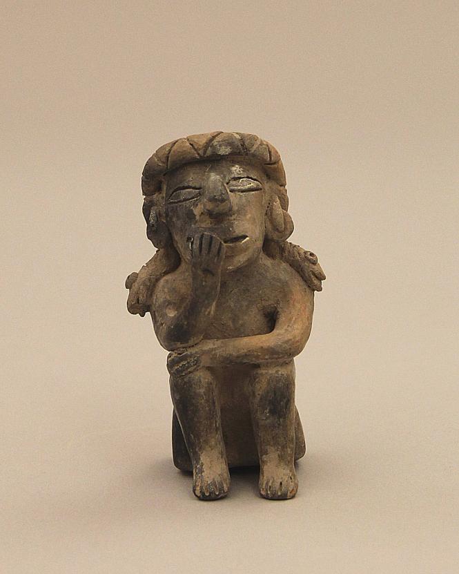 Seated figure chewing coca